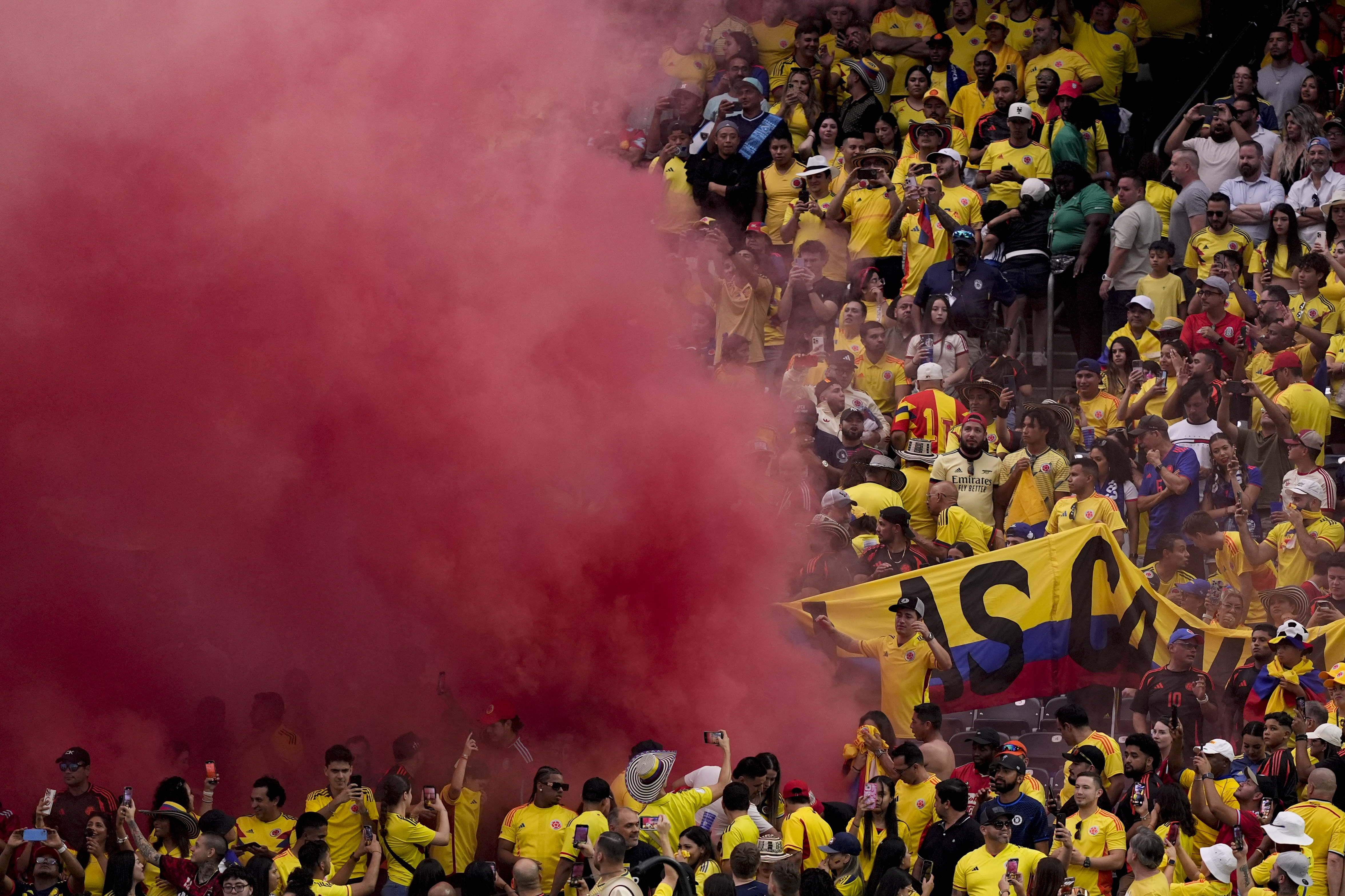 Smoke from a flare spreads in the stands of a Copa America Group D soccer match between Colombia and Paraguay in Houston, Monday, June 24, 2024. (AP Photo/David J. Phillip)