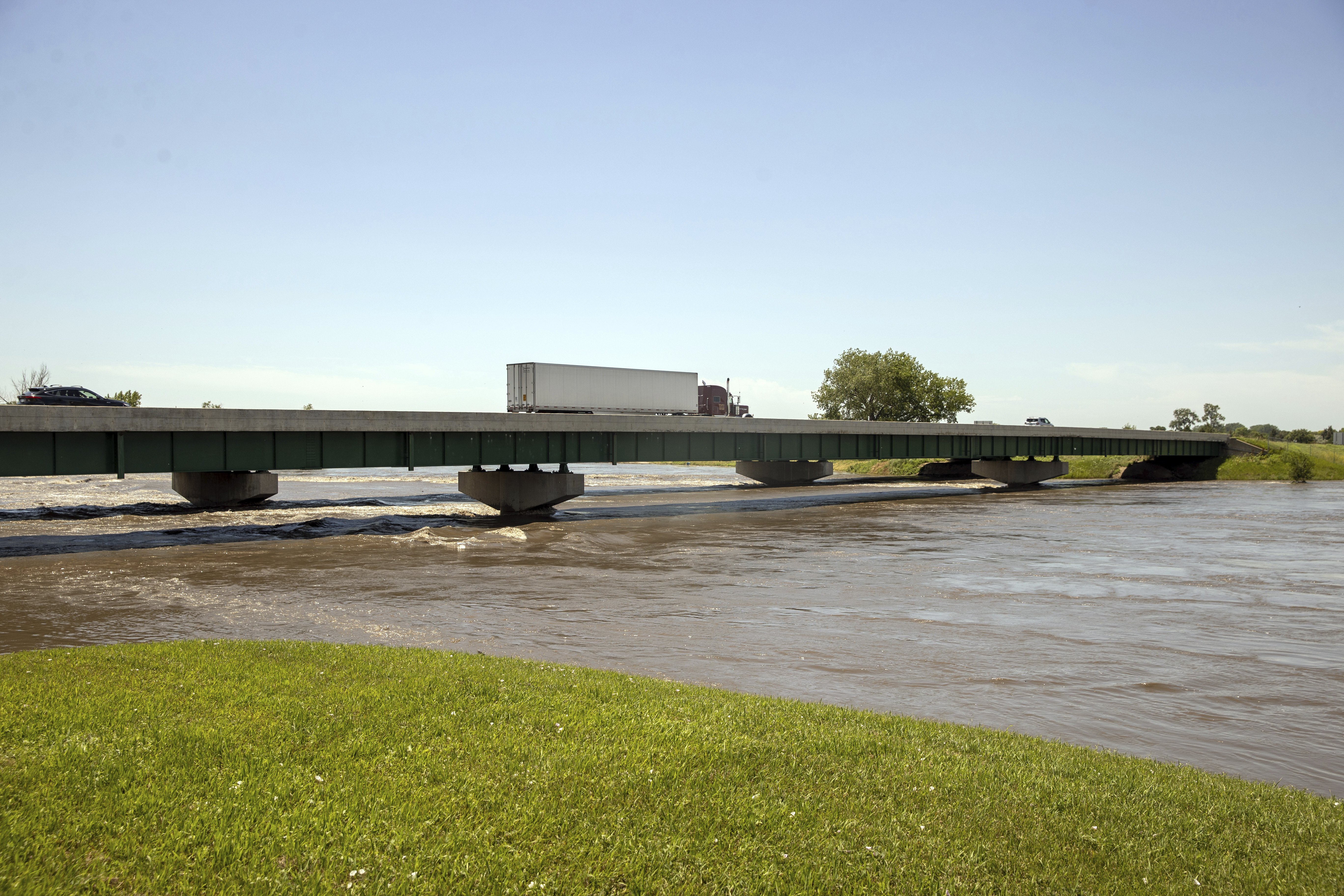 Vehicles cross a bridge over rising floodwaters at the Iowa-South Dakota border into Dakota Dunes, S.D., on Monday, June 24, 2024. (AP Photo/Josh Jurgens)