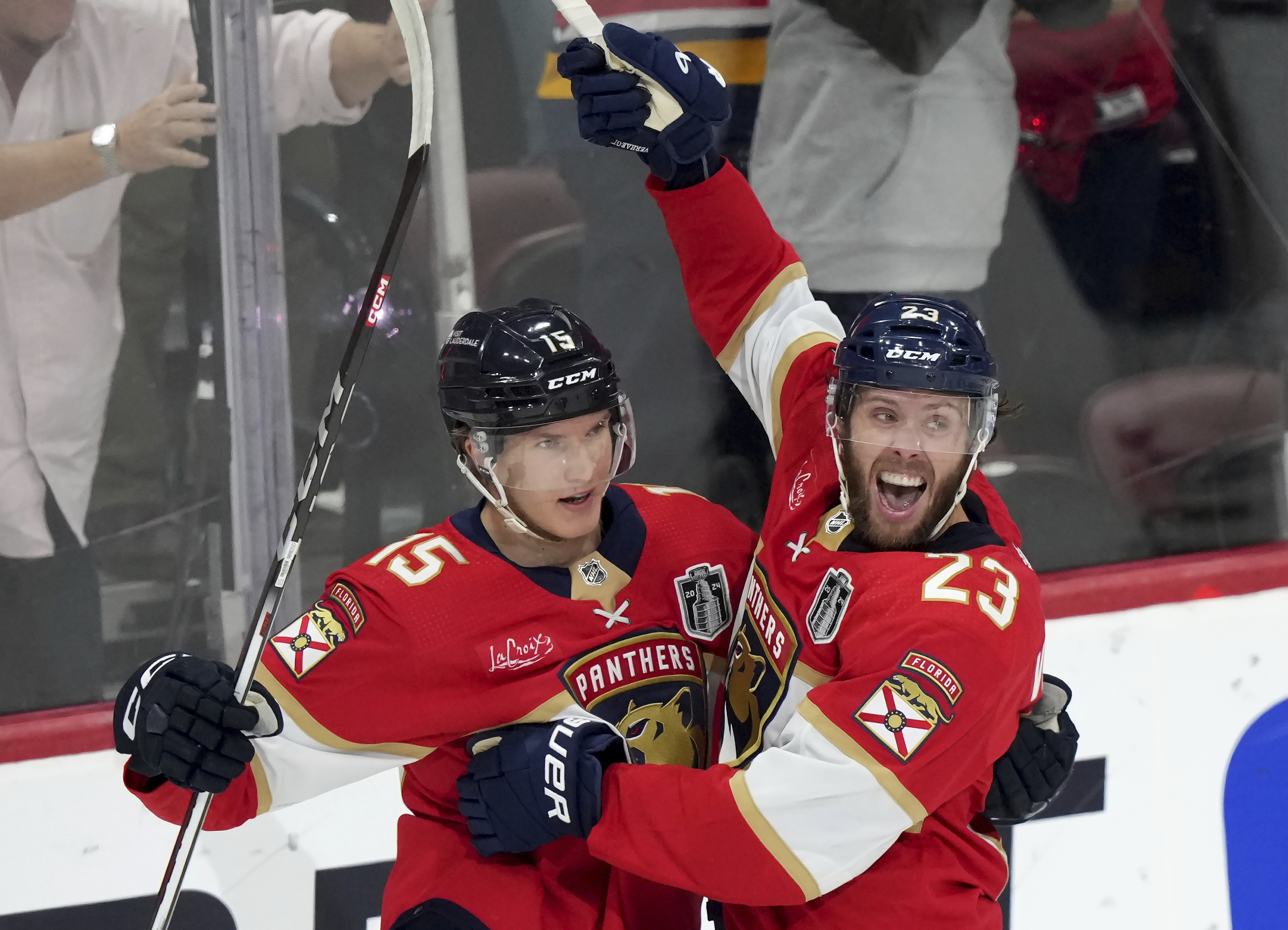 Florida Panthers forward Carter Verhaeghe (23) celebrates his goal with teammate Anton Lundell (15) after scoring on the Edmonton Oilers during the first period of Game 7 of the NHL hockey Stanley Cup Final on Monday, June 24, 2024, in Sunrise, Fla. (Nathan Denette/The Canadian Press via AP)